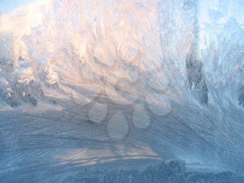 frosty natural pattern and sunlight on winter windowpane