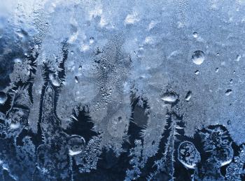 blue frosty natural pattern on winter windowpane