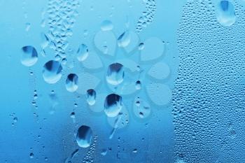 Large and fine water drops on glass
