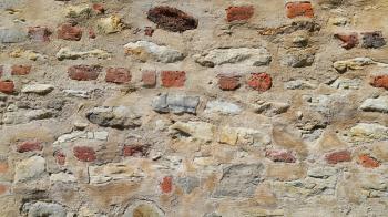 Very ancient wall with stones and bricks, close-up texture.