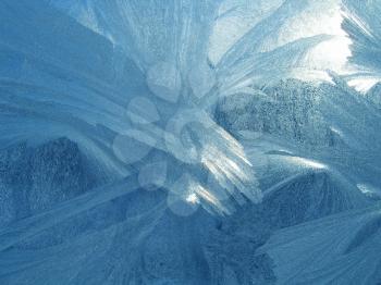 Ice pattern and sunlight on winter window