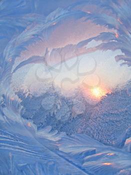 Nature background with ice pattern and sunlight on winter glass