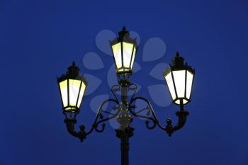 Vintage street light against the evening blue sky