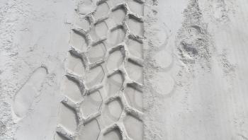 Wheel track and footprints on the sandy beach