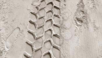 Wheel track and footprints on the sandy beach