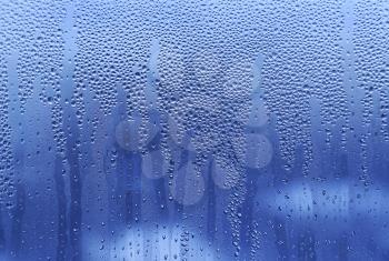Water drops on glass naural bright blue background