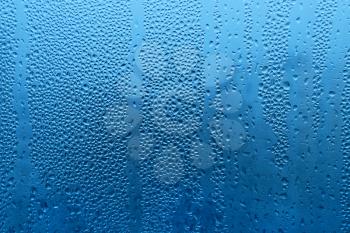 Nature blue background with water drops on glass