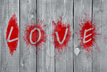 Bright red word Love on a grey wooden wall 