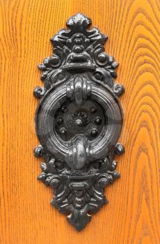 Old door knocker on wooden background