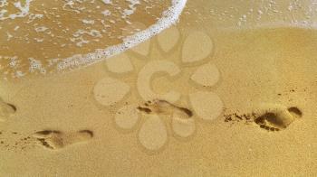 Nature background with sea water and footprints in the sand at the beach