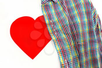 Closeup of T-shirt with a red heart on a white background under colorful checkered unbuttoned shirt