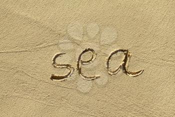 Closeup of natural sand background with scrawled word ''Sea''