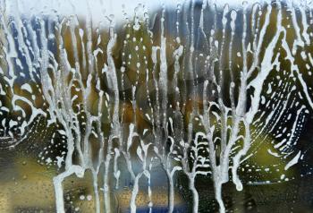 Close-up of natural background with soap foam abstract pattern on glass