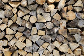 Firewood pile stacked chopped wood trunks, close-up background
