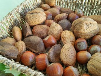 Mix of different types nuts close-up in wicker dish