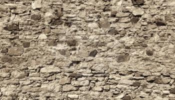 Ancient wall with stones, cobblestones and bricks. Close-up toned texture.