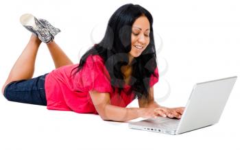 Royalty Free Photo of a Young Girl Lying on the Floor Typing on her Laptop