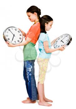 Royalty Free Photo of Two Girls Standing Back to Back Holding Clocks