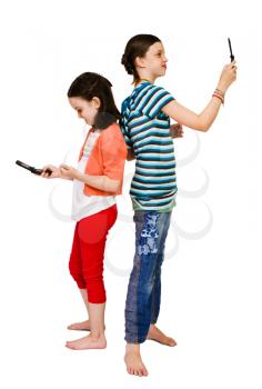 Royalty Free Photo of Two Girls Standing Back to Back and Texting on their Cell Phones