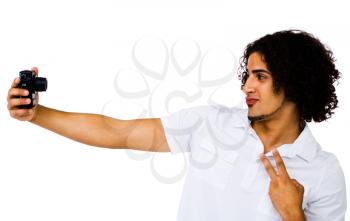 Royalty Free Photo of a Young Man Taking a Picture of Himself and Giving the peace Sign