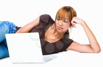 Royalty Free Photo of a Young Woman Lying on the Floor Using a Laptop