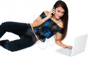 Royalty Free Photo of a Woman Using a Laptop and Talking on Her Mobile Phone