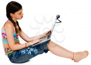 Royalty Free Photo of a Young Girl Sitting and Using a Laptop