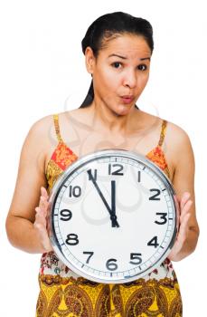 Woman holding a clock and puckering isolated over white