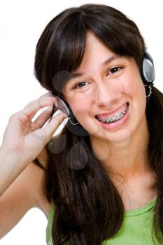 Asian teenage girl wearing headphones and listening to music isolated over white