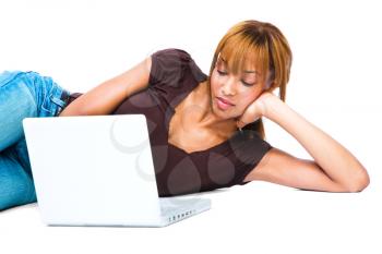 Young woman lying on the floor and using a laptop isolated over white