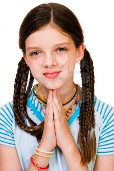 Confident girl praying and smiling isolated over white