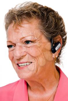 Woman wearing a bluetooth and smiling isolated over white