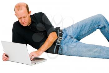 Man lying and using a laptop isolated over white