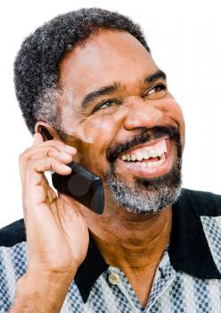 Man talking on a mobile phone and smiling isolated over white