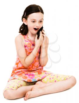Shocked girl talking on a mobile phone isolated over white