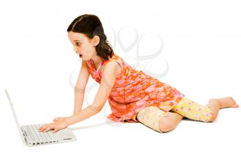 Shocked girl using a laptop and posing isolated over white