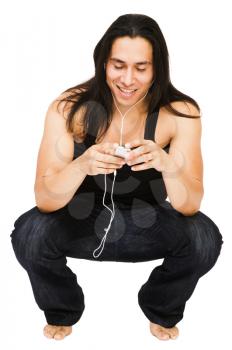 Close-up of a young man listening to MP3 player isolated over white