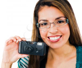 Confident woman photographing with a camera and smiling isolated over white