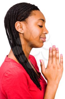 Confident teenage girl praying and smiling isolated over white
