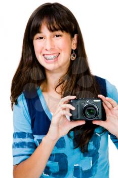 Mixedrace teenager photographing with a camera and smiling isolated over white