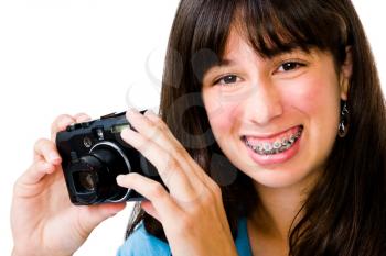 Smiling teenager photographing with a camera isolated over white