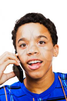 Latin teenage boy talking on a mobile isolated over white