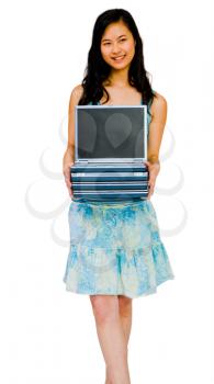 Smiling woman holding a stack of laptops isolated over white
