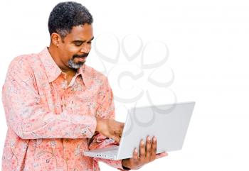 Smiling mature man using a laptop isolated over white