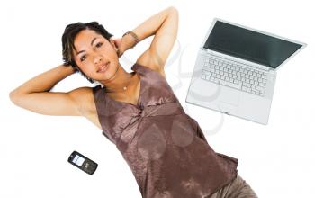 Mixed race young woman lying near a laptop isolated over white