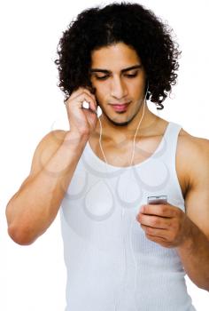 Latin American man listening to music on a MP3 player isolated over white
