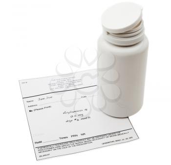 Close-up of a pill bottle with a medical report isolated over white