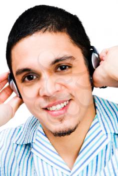 Latin American man listening to headphones isolated over white