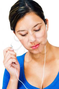 Close-up of a woman listening to music on an mp3 player isolated over white