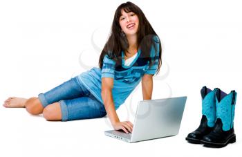 Confident teenage girl using a laptop and smiling isolated over white